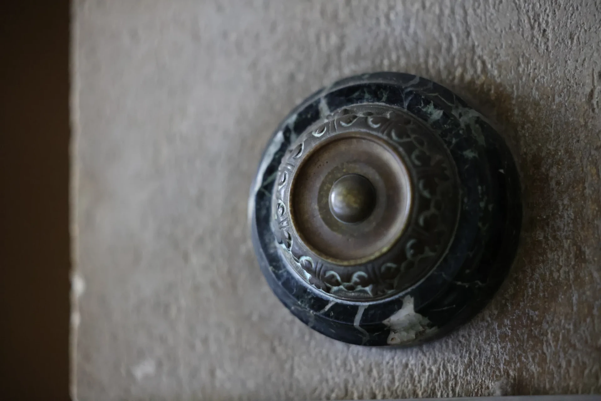 Sonnette de marbre et de bronze encastrée dans la pierre